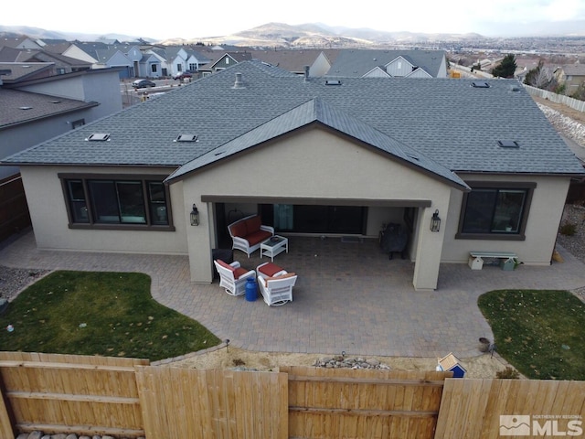 back of property featuring a mountain view and a patio