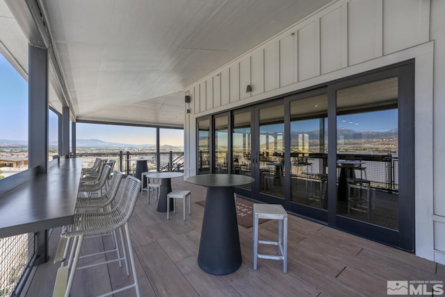 sunroom featuring a wealth of natural light and a mountain view