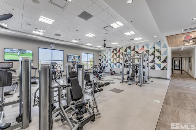 workout area with a paneled ceiling and ceiling fan