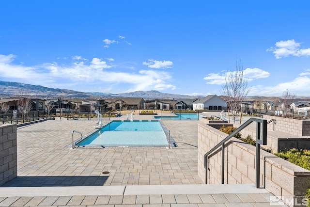 view of swimming pool with a patio area and a mountain view