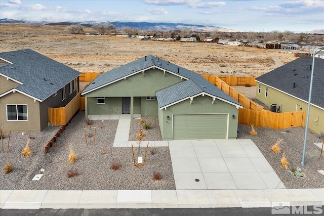 ranch-style home featuring central air condition unit, a mountain view, and a garage