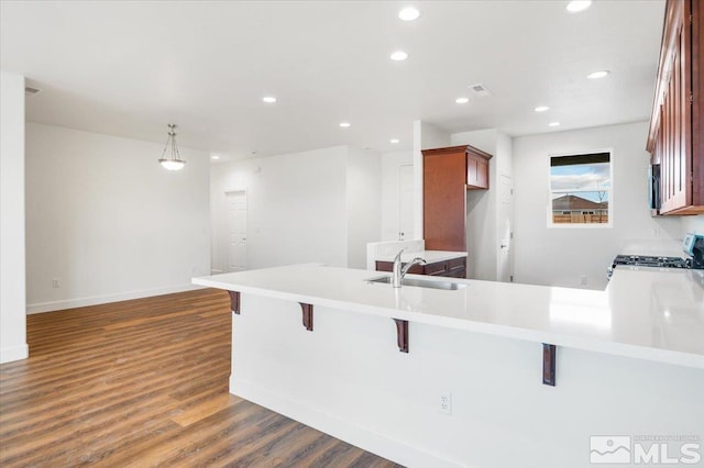 kitchen featuring kitchen peninsula, stove, a breakfast bar, and dark hardwood / wood-style floors