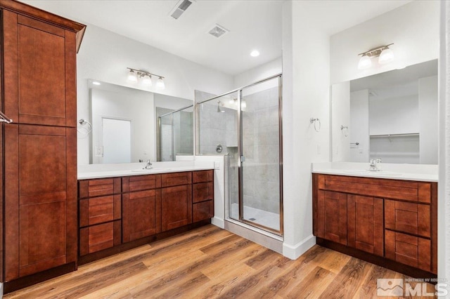 bathroom with vanity, an enclosed shower, and wood-type flooring