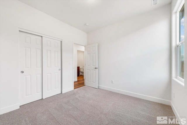 unfurnished bedroom featuring carpet flooring and a closet