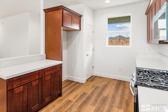 kitchen with gas stove and light hardwood / wood-style floors