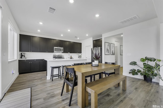 dining area with sink and light wood-type flooring