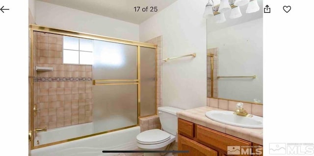 full bathroom with vanity, toilet, and bath / shower combo with glass door