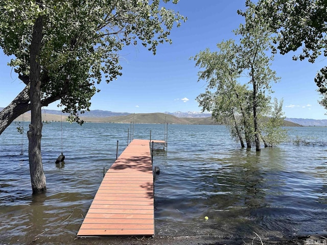 view of dock with a water and mountain view