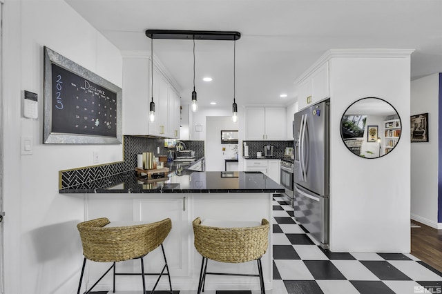 kitchen featuring pendant lighting, white cabinets, a kitchen breakfast bar, appliances with stainless steel finishes, and kitchen peninsula