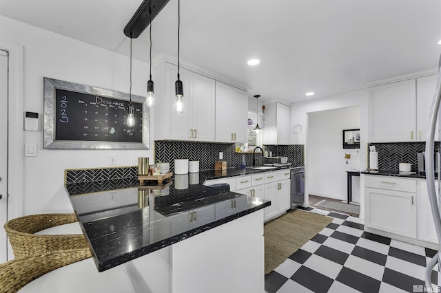 kitchen with white cabinets, backsplash, decorative light fixtures, and sink