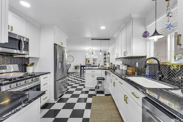 kitchen featuring pendant lighting, white cabinets, stainless steel appliances, and sink