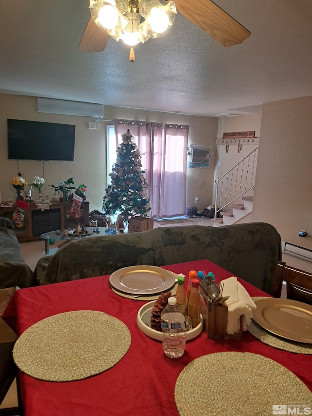 living room featuring ceiling fan and a textured ceiling