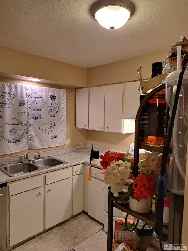 kitchen featuring white cabinetry, sink, and a textured ceiling