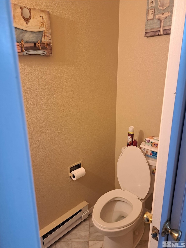 bathroom featuring toilet, tile patterned flooring, and a baseboard heating unit