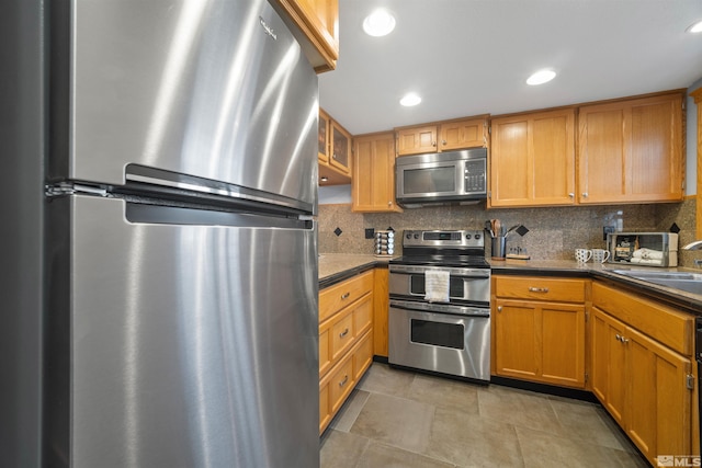 kitchen with backsplash, stainless steel appliances, and sink