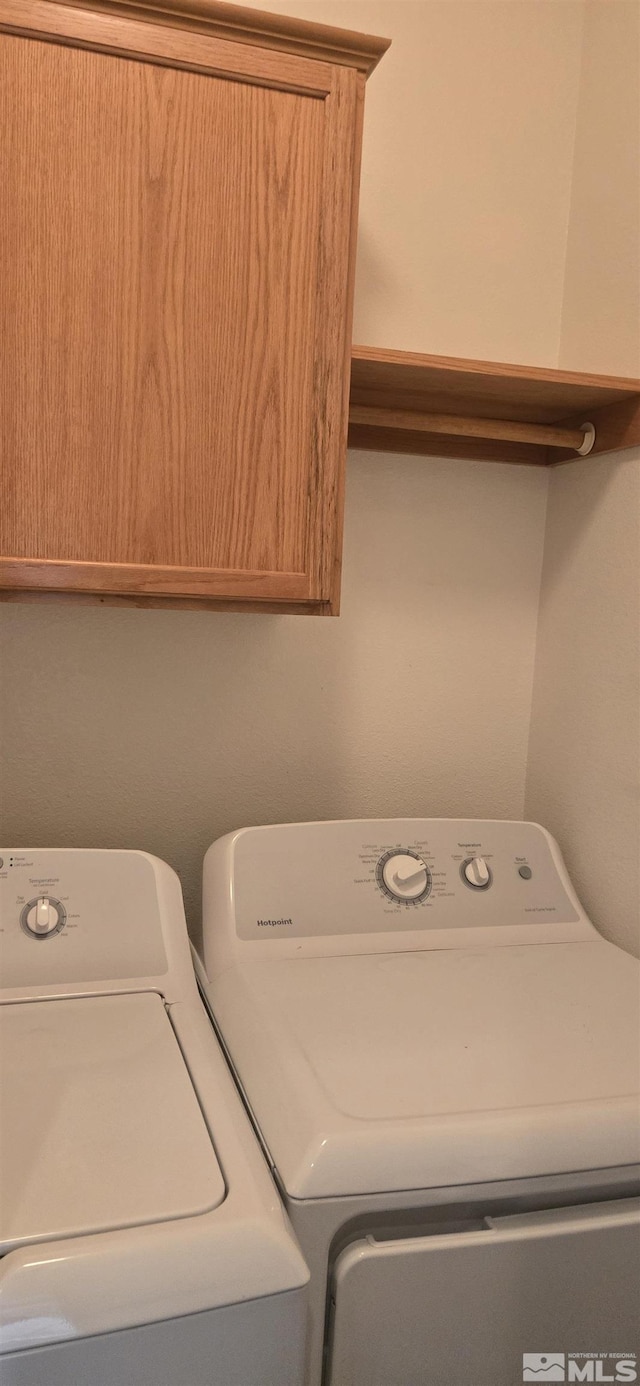 laundry room featuring cabinets and washer and clothes dryer