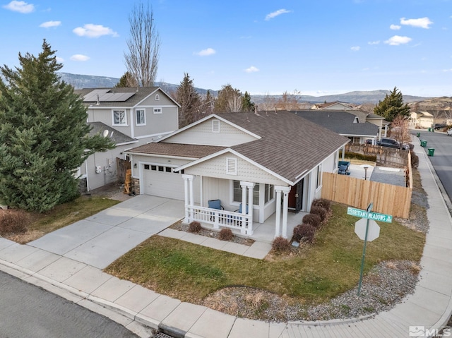 view of front facade with a mountain view, a porch, and a garage