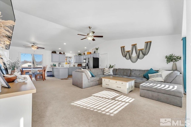 carpeted living room featuring ceiling fan and vaulted ceiling