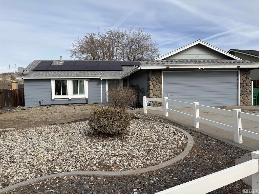 ranch-style house featuring solar panels and a garage