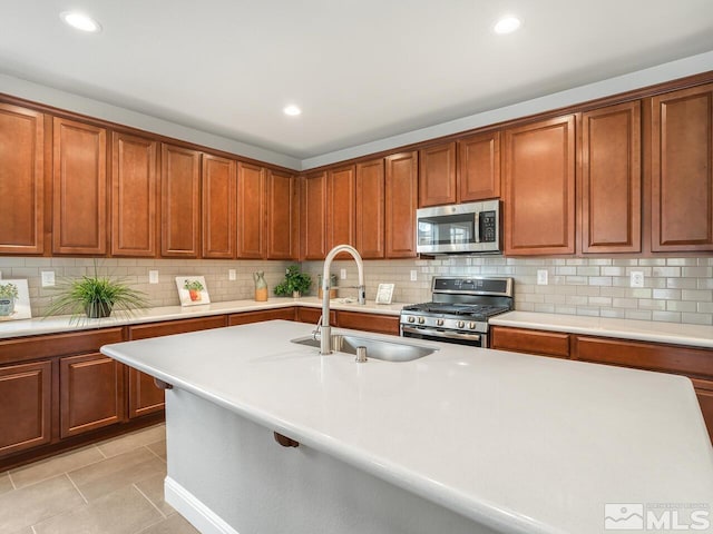 kitchen featuring light tile patterned floors, sink, appliances with stainless steel finishes, and tasteful backsplash