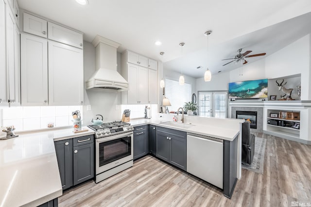 kitchen featuring premium range hood, sink, vaulted ceiling, gray cabinets, and stainless steel appliances