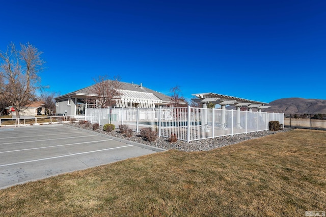 exterior space with a lawn, a mountain view, and a pergola