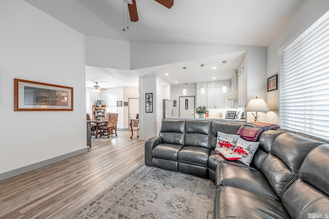 living room featuring ceiling fan, light hardwood / wood-style floors, and high vaulted ceiling