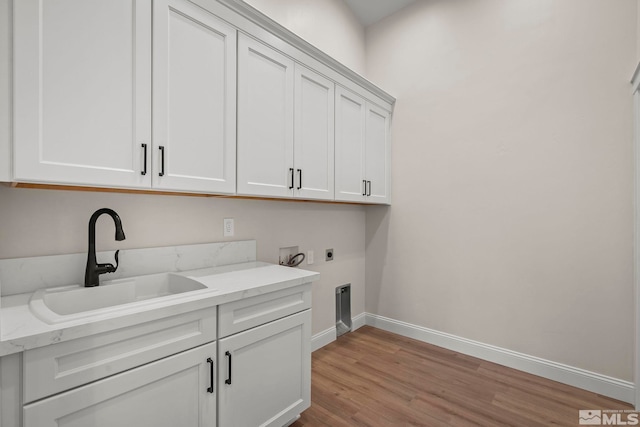 laundry area featuring sink, cabinets, washer hookup, electric dryer hookup, and light wood-type flooring