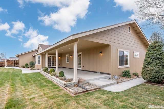 rear view of property with a lawn and a patio area