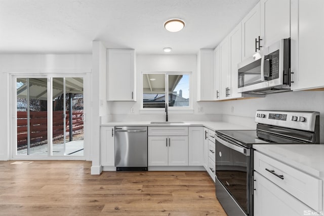 kitchen with white cabinets, sink, and stainless steel appliances