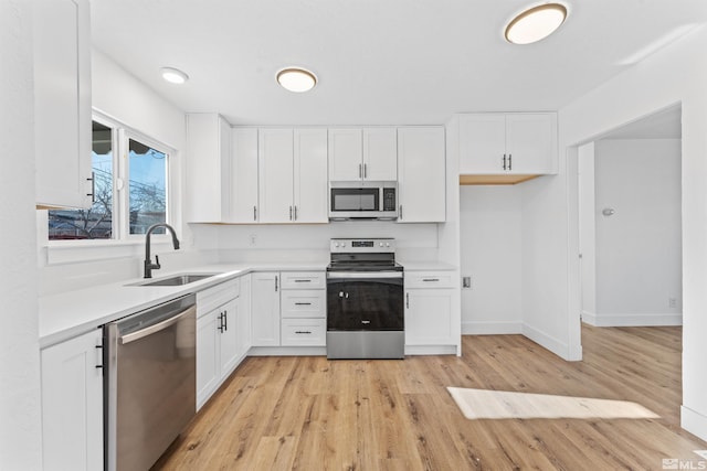 kitchen featuring light hardwood / wood-style floors, sink, white cabinetry, and stainless steel appliances