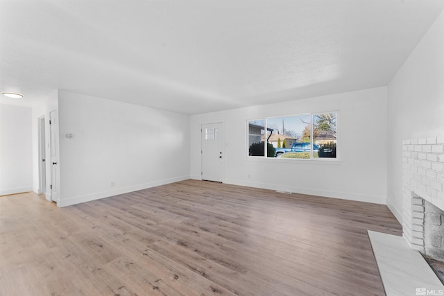 unfurnished living room with light wood-type flooring and a fireplace