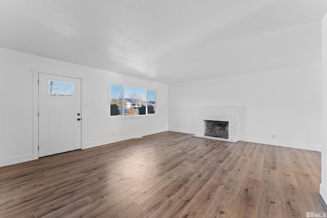 unfurnished living room featuring a fireplace and wood-type flooring