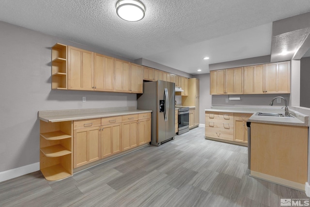 kitchen with appliances with stainless steel finishes, light brown cabinets, a textured ceiling, and sink