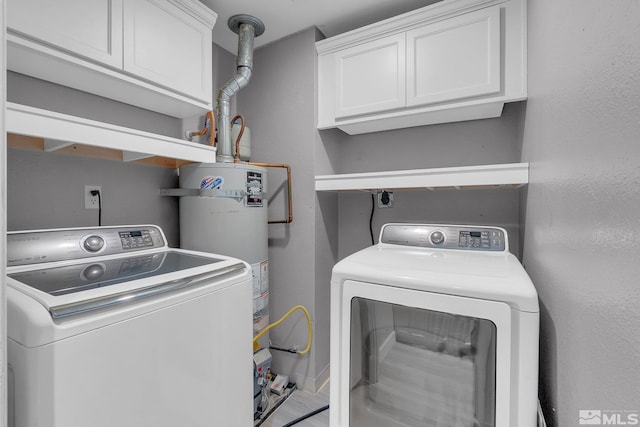 laundry area with cabinets, washing machine and clothes dryer, and water heater