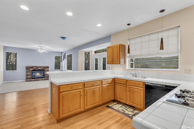 kitchen featuring dishwasher, pendant lighting, and tile counters