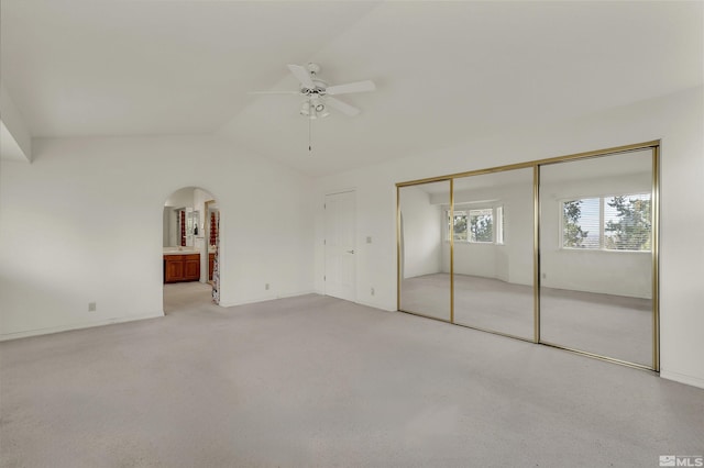 unfurnished bedroom with ceiling fan, light carpet, and vaulted ceiling