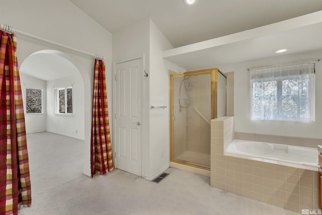 bathroom featuring independent shower and bath and lofted ceiling