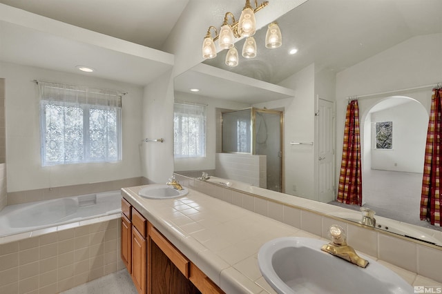 bathroom with vanity, independent shower and bath, and vaulted ceiling