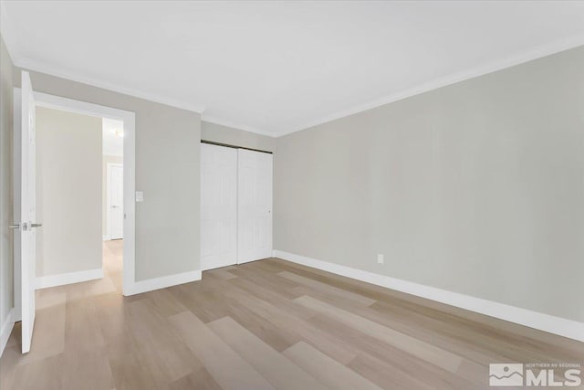 unfurnished bedroom featuring light wood-type flooring, crown molding, and a closet