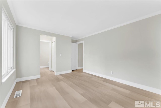 spare room featuring light hardwood / wood-style floors and ornamental molding