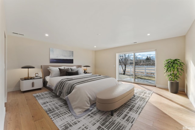 bedroom with access to exterior and light hardwood / wood-style floors