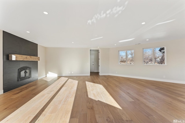 unfurnished living room featuring light wood-type flooring and a fireplace