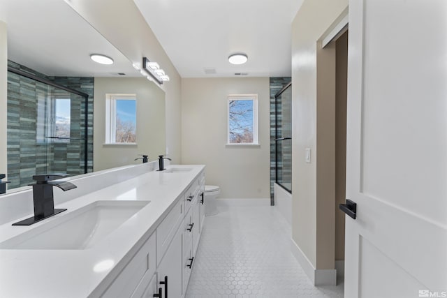 full bathroom featuring tile patterned floors, vanity, toilet, and enclosed tub / shower combo