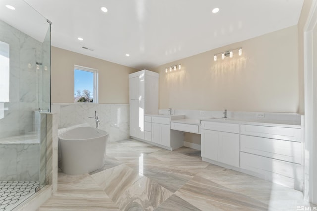 bathroom with vanity, shower with separate bathtub, and tile walls