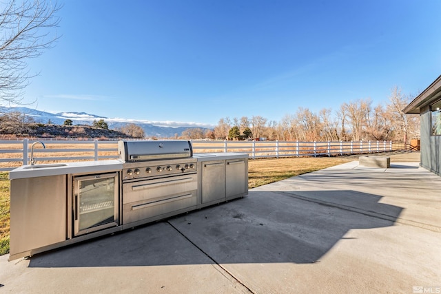 view of patio / terrace with sink, a grill, a rural view, a mountain view, and area for grilling