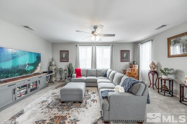 carpeted living room featuring a wealth of natural light and ceiling fan