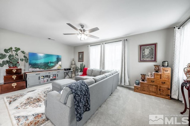 carpeted living room with a wealth of natural light and ceiling fan