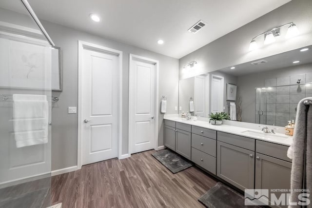 bathroom featuring vanity, wood-type flooring, and walk in shower