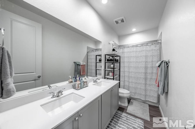 bathroom featuring vanity, toilet, wood-type flooring, and walk in shower